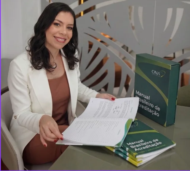 Núbia Paiva com o Manual Brasileiro de Acreditação ONA